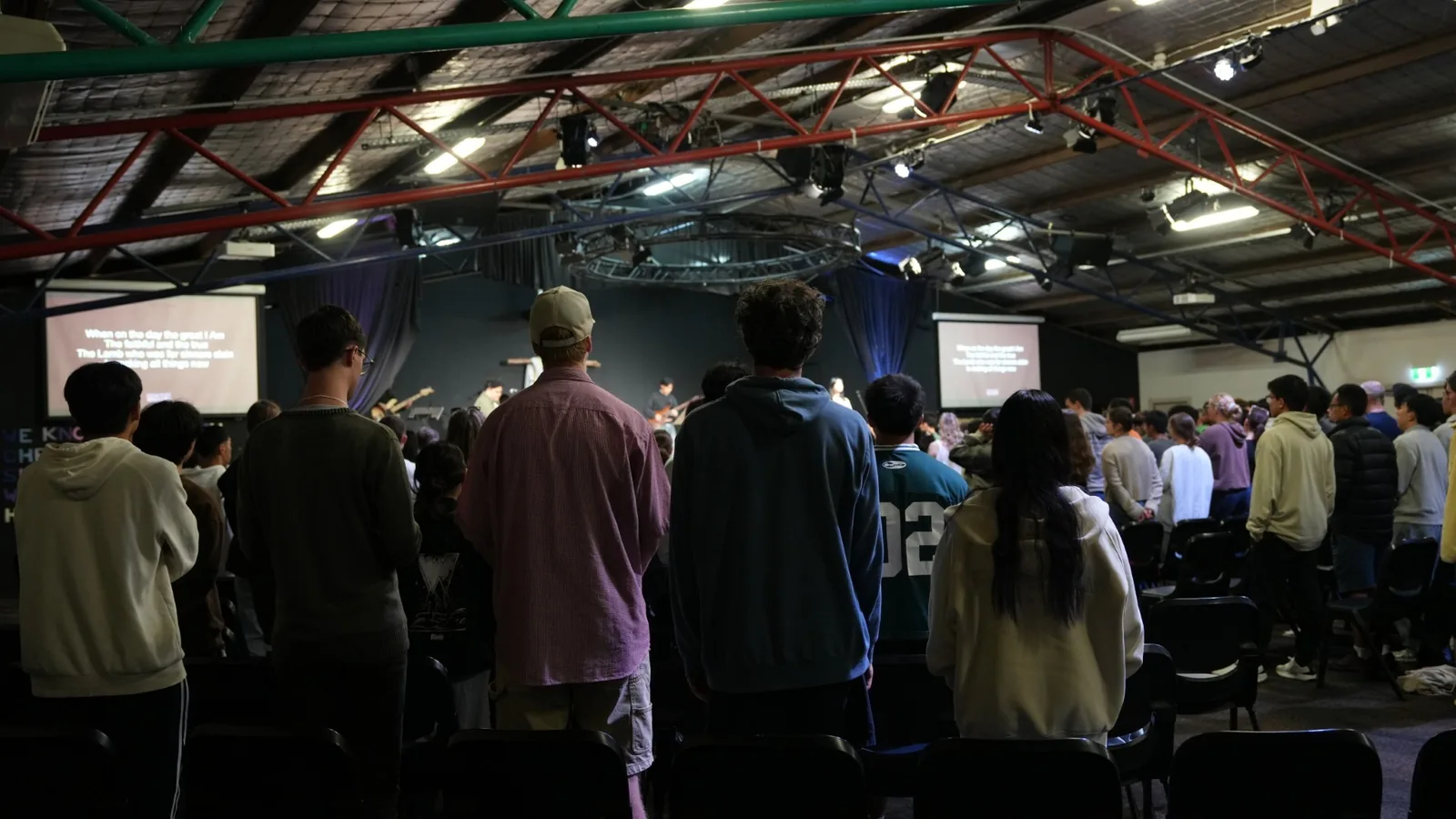 Students standing and singing in the main session